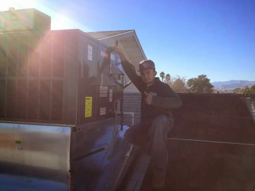 HVAC technician performing HVAC Inspection on a rooftop unit in Prospect