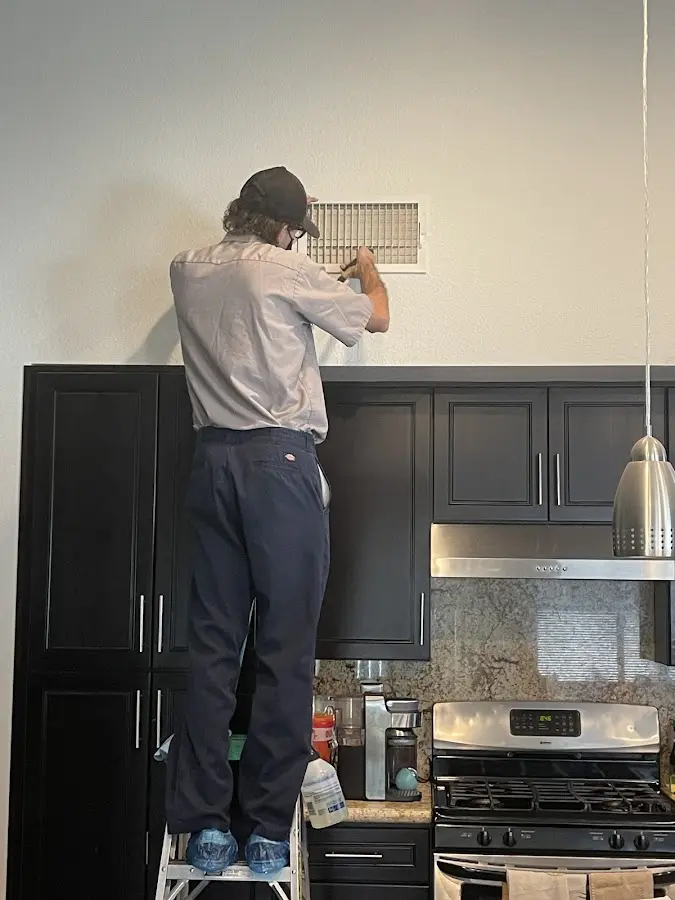 Technician inspecting an air vent during HVAC service in Prospect